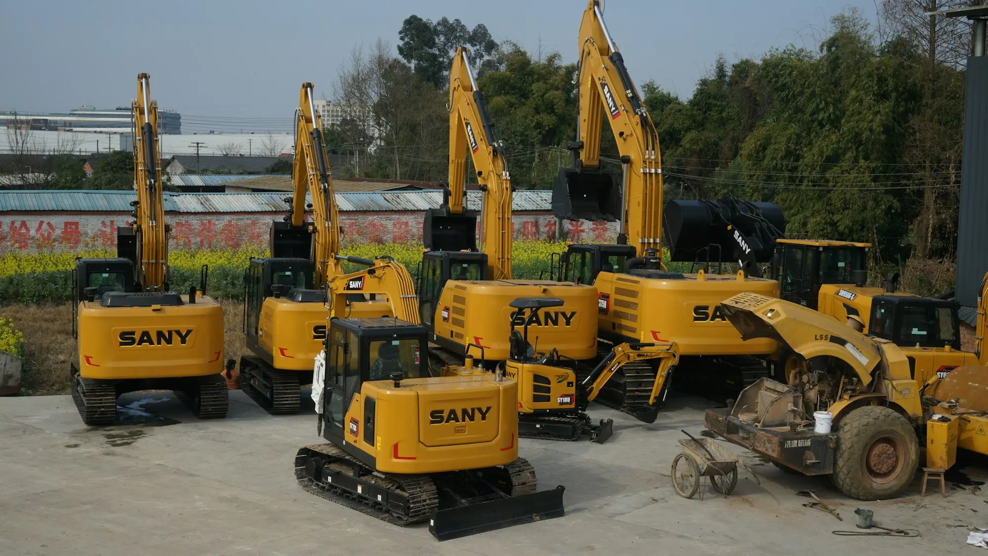 Row of yellow construction machines parked on site before a large contract starts